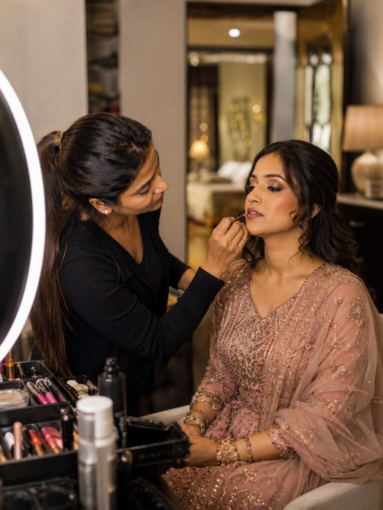 Professional makeup artist applying lipstick during home makeup service in Ghaziabad